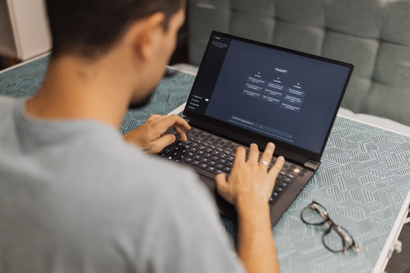 Pessoa digitando em notebook com a tela inicial do ChatGPT aberta